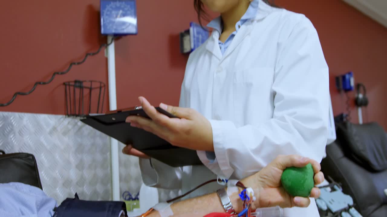 médico chequeando hombre mayor donando sangre 4k