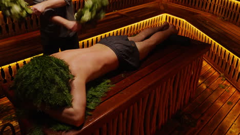 man in a sauna receiving herbal treatment