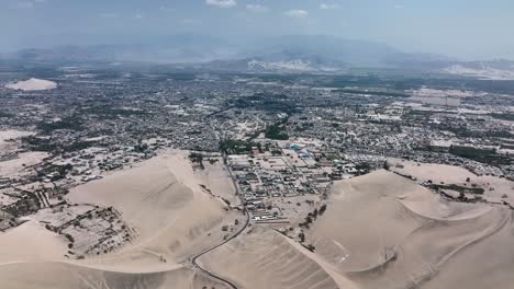 dunas de arena del desierto y ciudad de perú