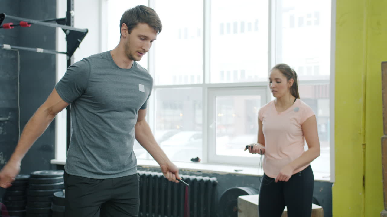 Man and woman jumping rope in gym