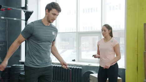 man and woman jumping rope in gym