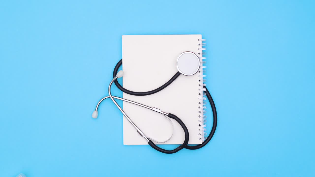 Prevenzione Covid-19 e strumenti medici appaiono intorno a un notebook con stetoscopio. Stop motion.