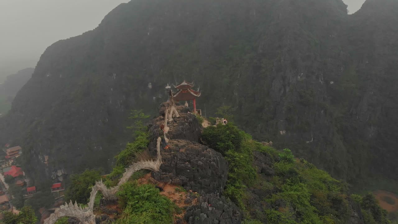 Toàn cảnh từ trên cao những ngọn núi đá và điểm ngắm cảnh Hang Múa với người dân và sông ở Tam Cốc Ninh Bình Việt Nam dưới bầu trời nhiều mây