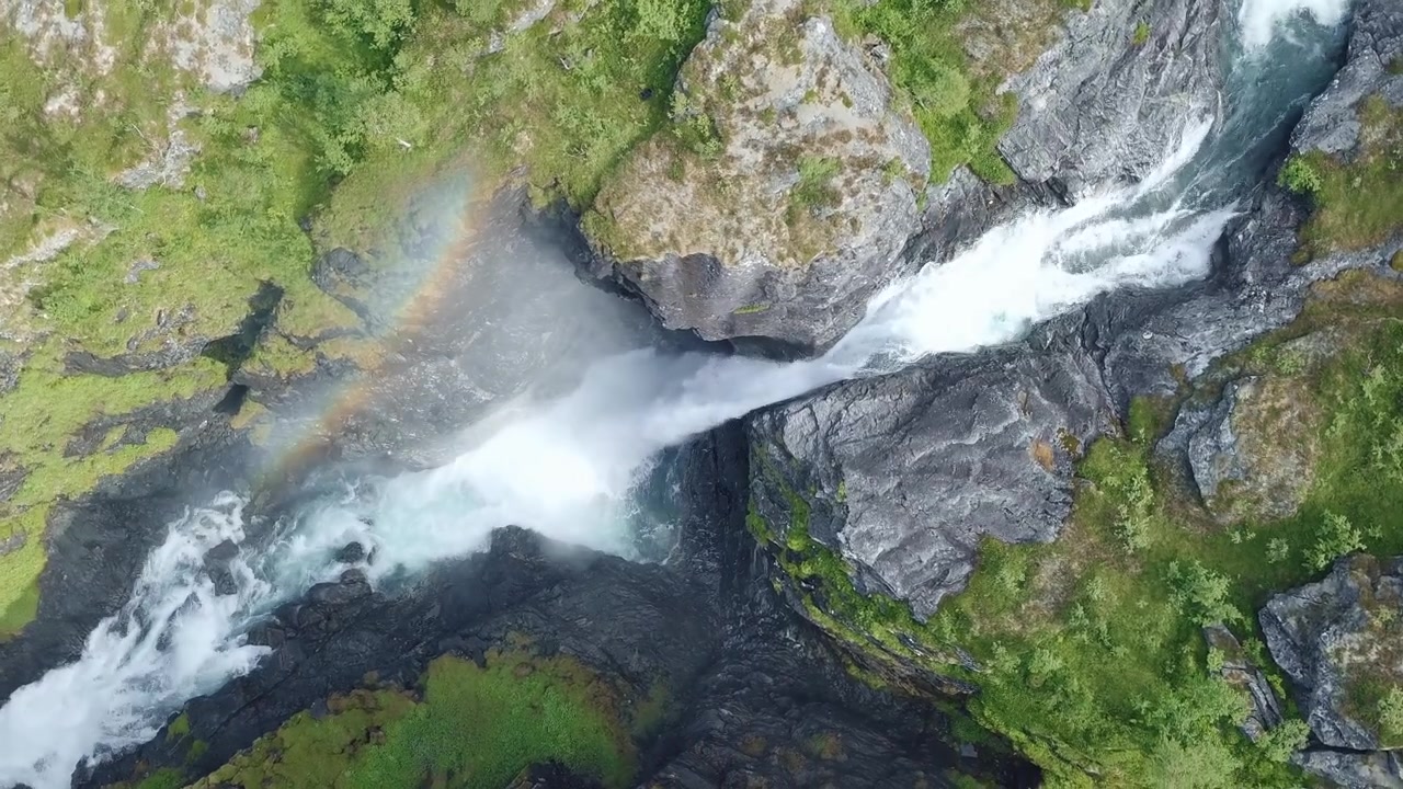 Vista aerea dall'alto di una cascata. La nebbia delle cascate crea un arcobaleno colorato. Vicino al Sentiero dei Troll in Norvegia