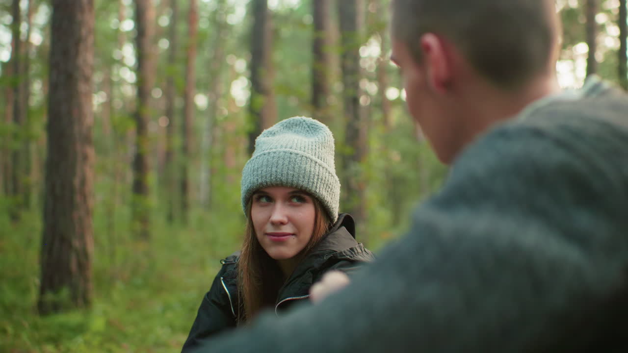 Close up of man focused on pumping air as woman gazes at him with intense emotion, sharing charged moment in outdoor setting with visible connection and attention between couple