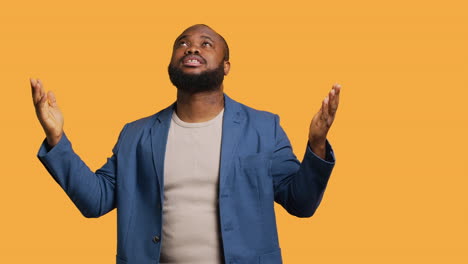 man looking up to sky hoping for miracle, studio background