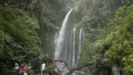 sightseers at a waterfall in indonesia