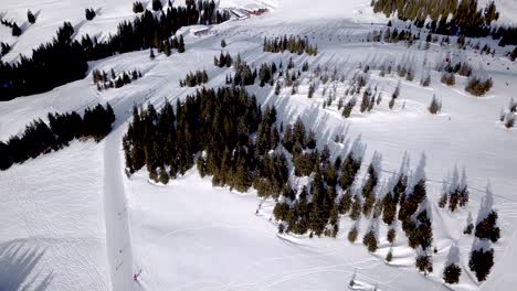 Aerial-view-of-People-Skiing-and-snowboarding-on-hill,-Ski-Resort