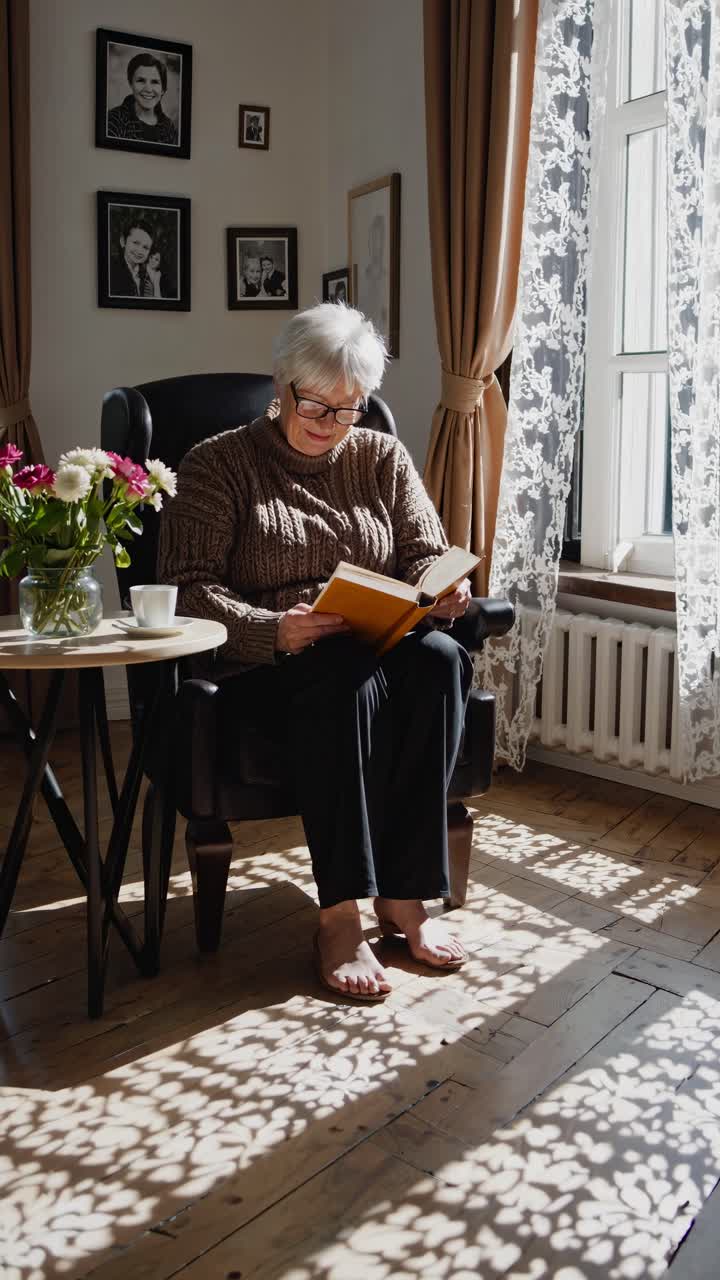 A cozy video scene of an elderly woman reading by a window