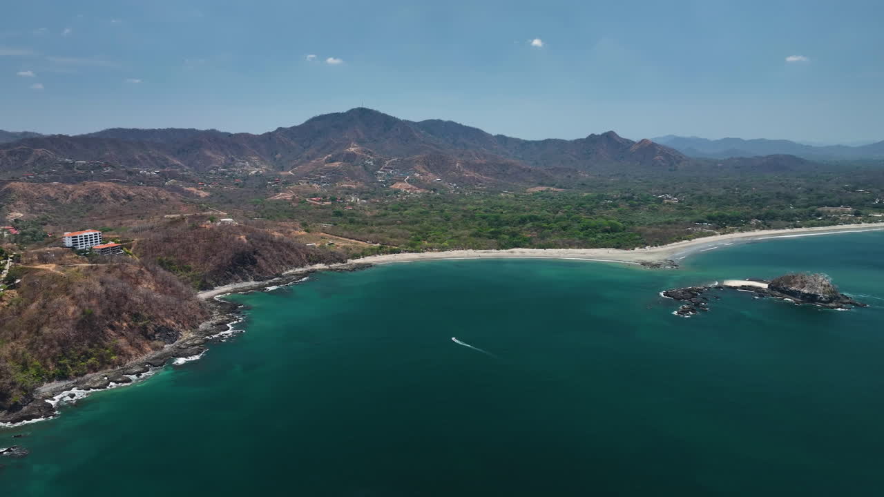 drone siguiendo a un barco que conduce en la costa de flamingo guanacaste, costa rica