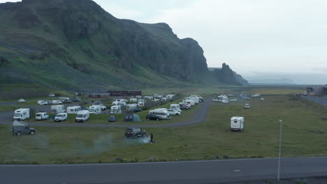 Autocaravanas-Con-Vista-Aérea-Estacionadas-En-El-Fondo-Paisaje-Natural-De-Montaña-Cubierto-De-Musgo-En-Islandia.-Drone-View-Autocaravanas-Camping-Camping-En-Tierras-Altas-Cubiertas-De-Hierba-En-El-Sur-De-Islandia
