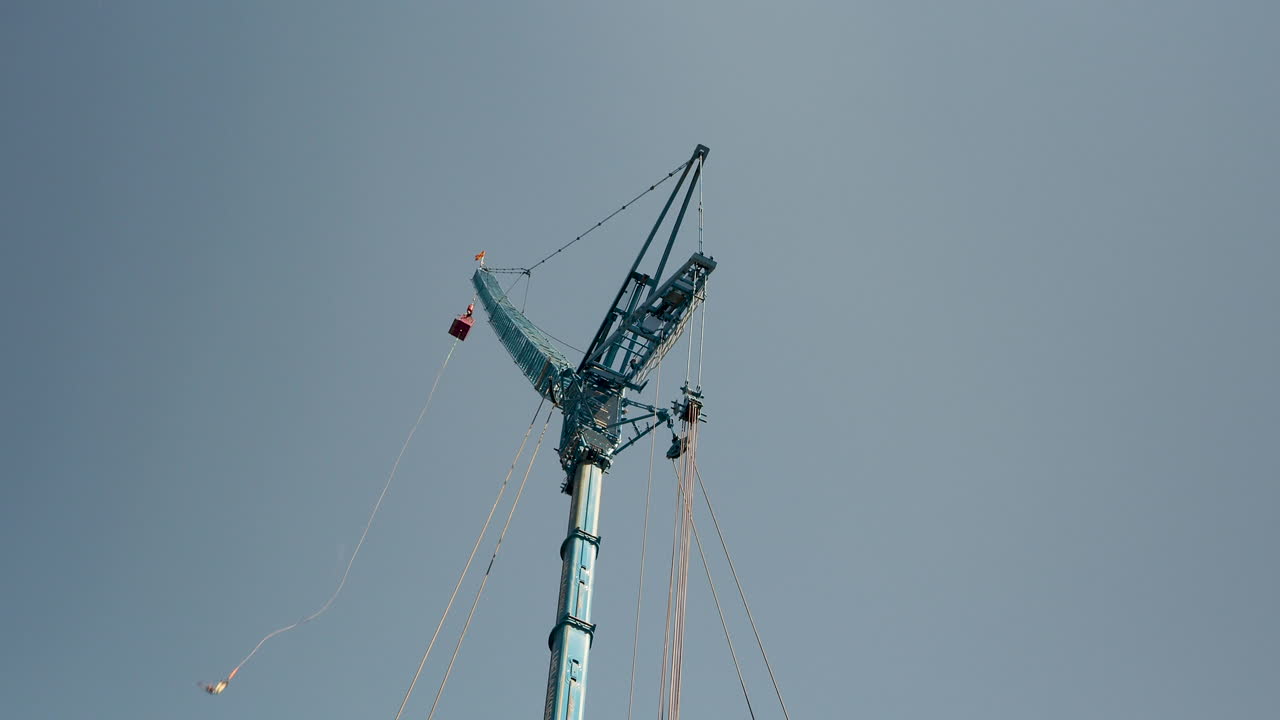 번지점프 타워를 올려다보는 와이드샷, 누군가 뛰어내리는 모습