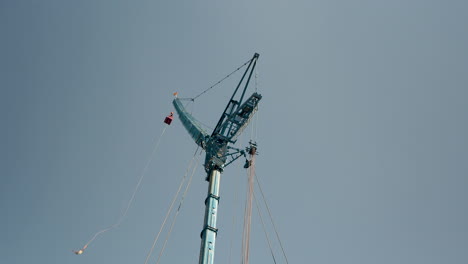 Wide-shot-looking-up-at-a-bungee-jumping-tower,-showing-someone-jumping-off