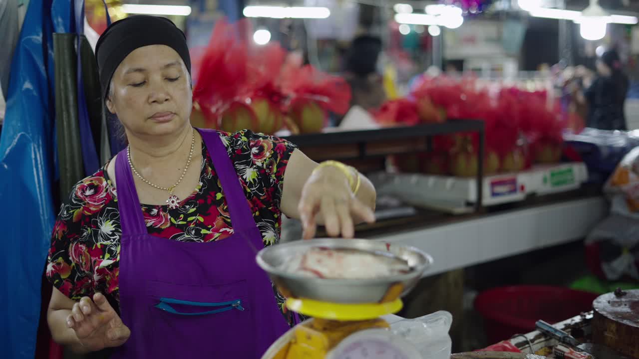 Woman Weighing Fish at a Market