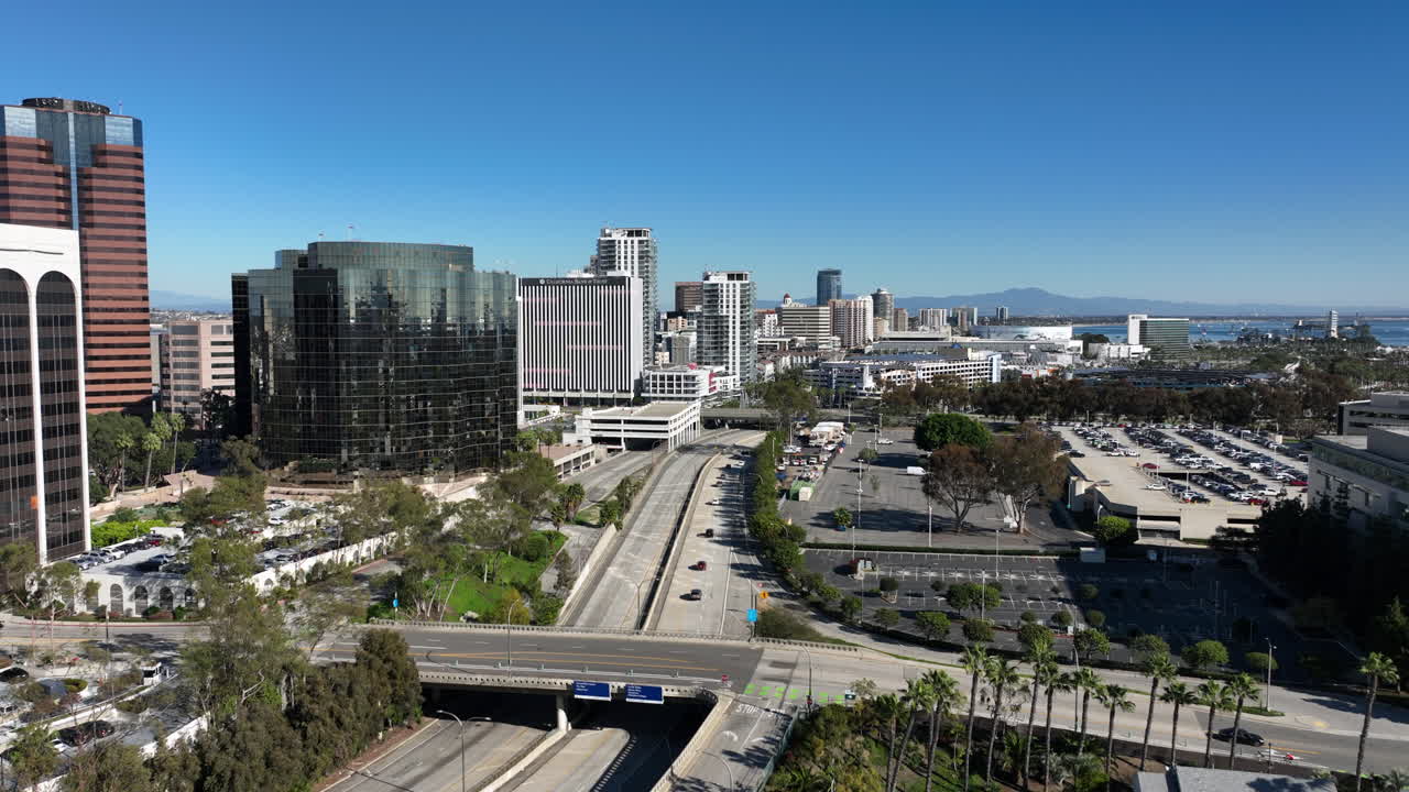 Veduta aerea del centro di Long Beach, California, che mostra la città costiera lungo Shoreline Drive verso lo skyline di Pike Outlets. Il filmato presenta edifici commerciali e strade costiere