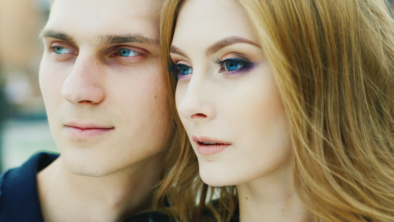 20-25년 된 젊은 부부의 초상화는 거리를 바라보며 매우 행복하게 웃고 있습니다.