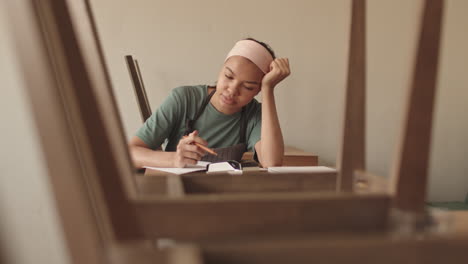 tired mixed-race waitress making financial report