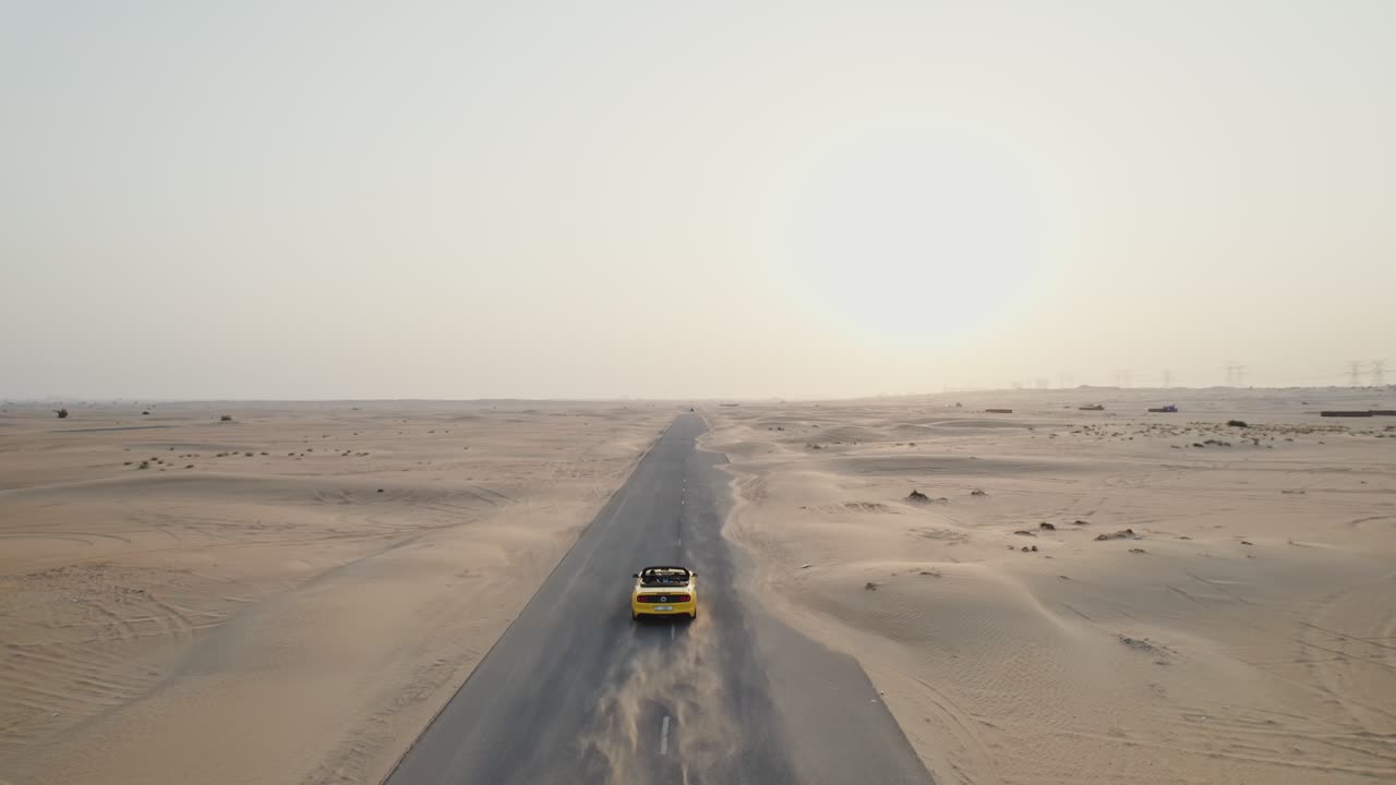 coche convertible amarillo en un camino del desierto