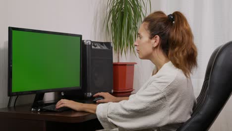 shot of woman typing on laptop keyboard with green screen, working from home, home office person using laptop computer with chroma key green screen.