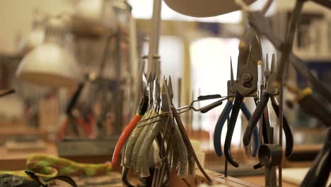 detail of workroom full of pliers, tweezers, splitters and other tools in slow motion