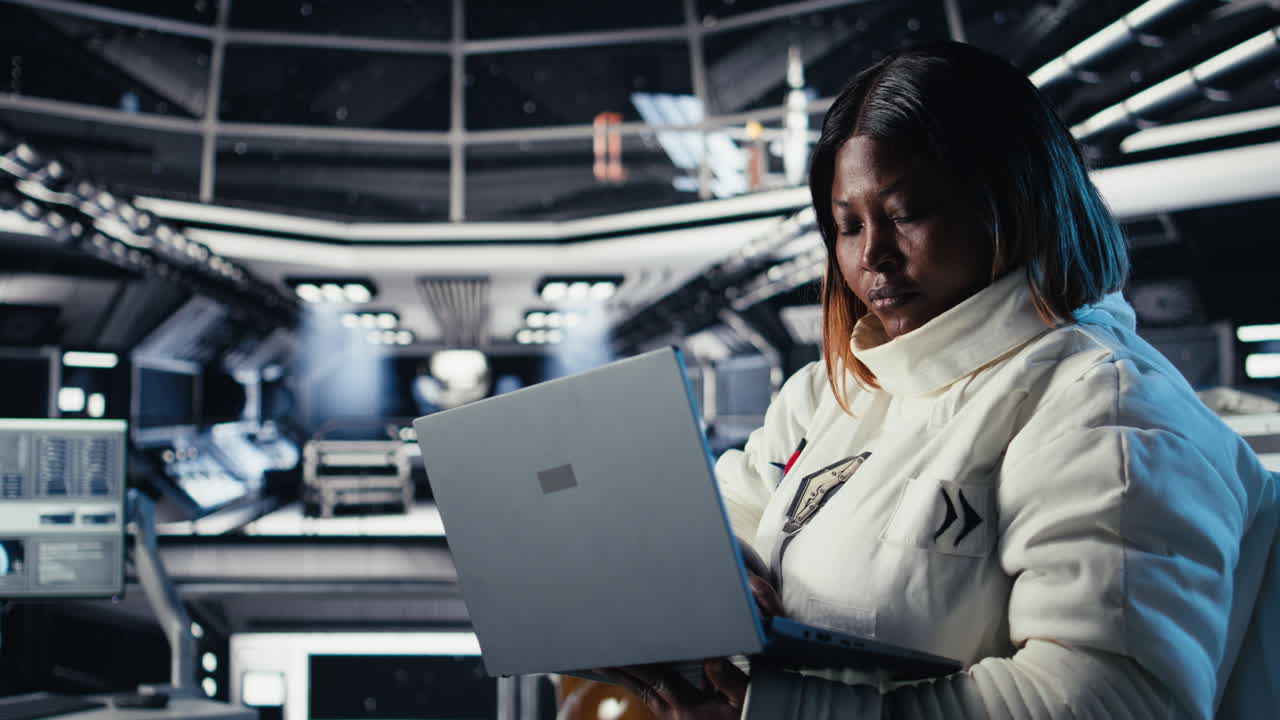 Astronaut monitoring systems on laptop during human expansion in space
