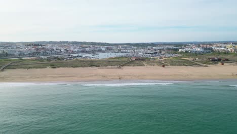 beautiful aerial view of praia de são roque, with clear water and the vibrant town of lagos in the background