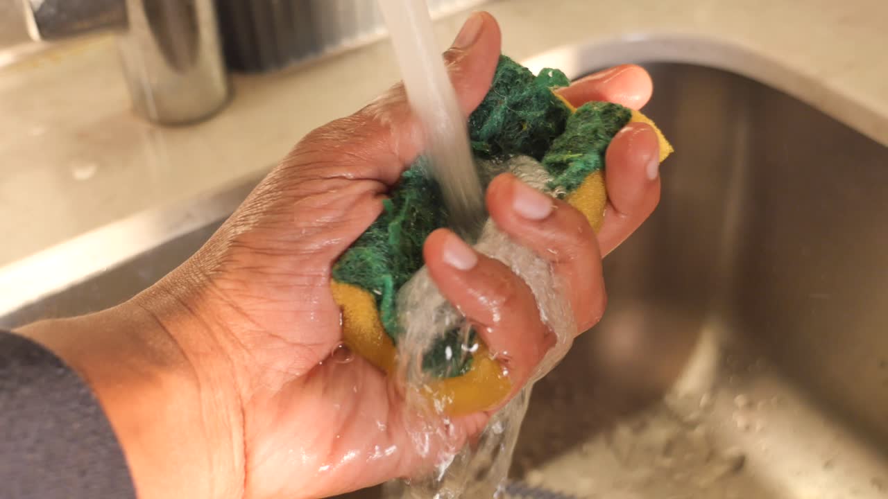 Washing a Cleaning Sponge Under Running Water