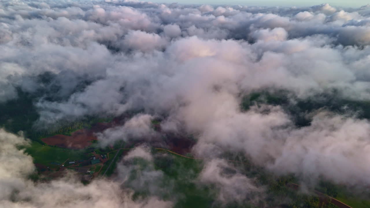 Green countryside of Latvia from above clouds, aerial view