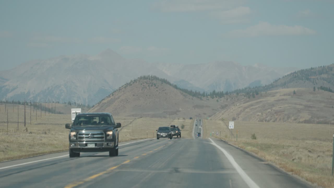 Vehicles on a highway with mountains in the background