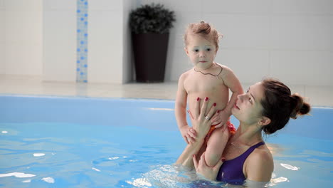 happy smiling toddler is jumping and diving under the water in the swimming pool. an underwater shot. slowmotion