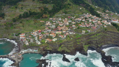 Seixal-Madeira-Coastline-drone-shot-with-waves-mountains-in-clouds-Panoramic-Ocean-Horizon-with-cliffs