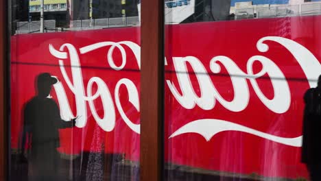 coca-cola billboard reflected in shop window