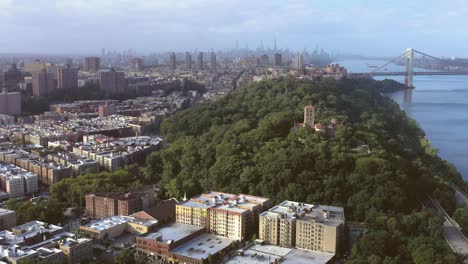 Magnífico-Vuelo-Aéreo-Hacia-El-Museo-De-Los-Claustros-En-El-Alto-Manhattan,-Nueva-York,-Con-Vistas-Panorámicas-De-Los-Barrios-De-La-Zona-Alta,-El-Centro-De-La-Ciudad-Y-El-Puente-George-Washington-Que-Cruza-El-Río-Hudson