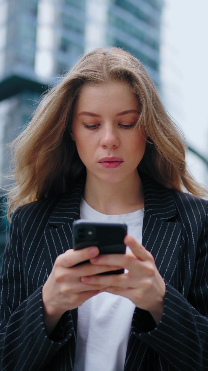 Giovane donna d'affari che usa lo smartphone in un contesto urbano