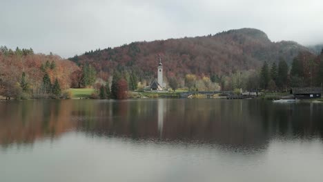 Iglesia-Del-Lago-Bohinj-En-La-Temporada-De-Otoño-Con-Colores-Asombrosos-Y-Un-Reflejo-Perfecto-Sobre-El-Lago