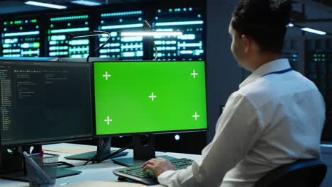 experto en la actualización de los sistemas de la sala de servidores utilizando una computadora de pantalla verde
