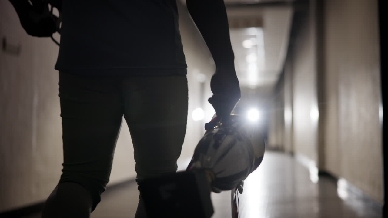 Football Player with Trophy in Hallway