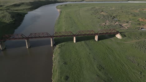 Low-aerial-flight-to-rusty-old-steel-railway-bridge-no-longer-in-use