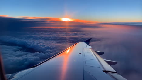 stunning sunrise/sunset view from an airplane window above the clouds