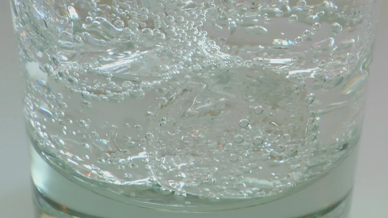 медленная вертикальная кастрюля из стекла, содержащая лед и газированную воду