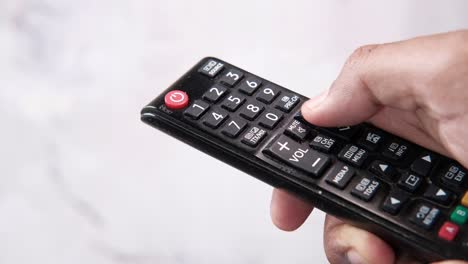 hand holding a black tv remote control