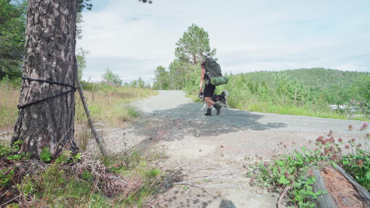 노르웨이 센자 섬의 안데르달렌 국립공원 근처에서 개와 함께 길을 걷고 있는 활동적인 백패커