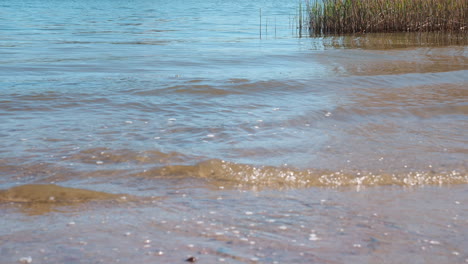 Ruhige-Wasseroberfläche-Mit-Wellen-An-Einer-Küste