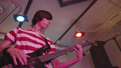 niño enérgico tocando la guitarra durante un ensayo de la banda en el estudio de grabación 3