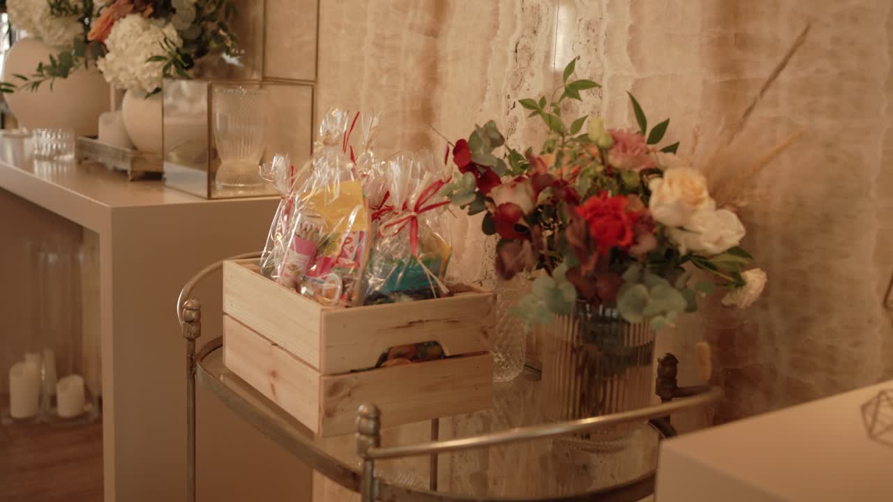 Tabletop gift display with flowers and wrapped favors for guests location irrelevant