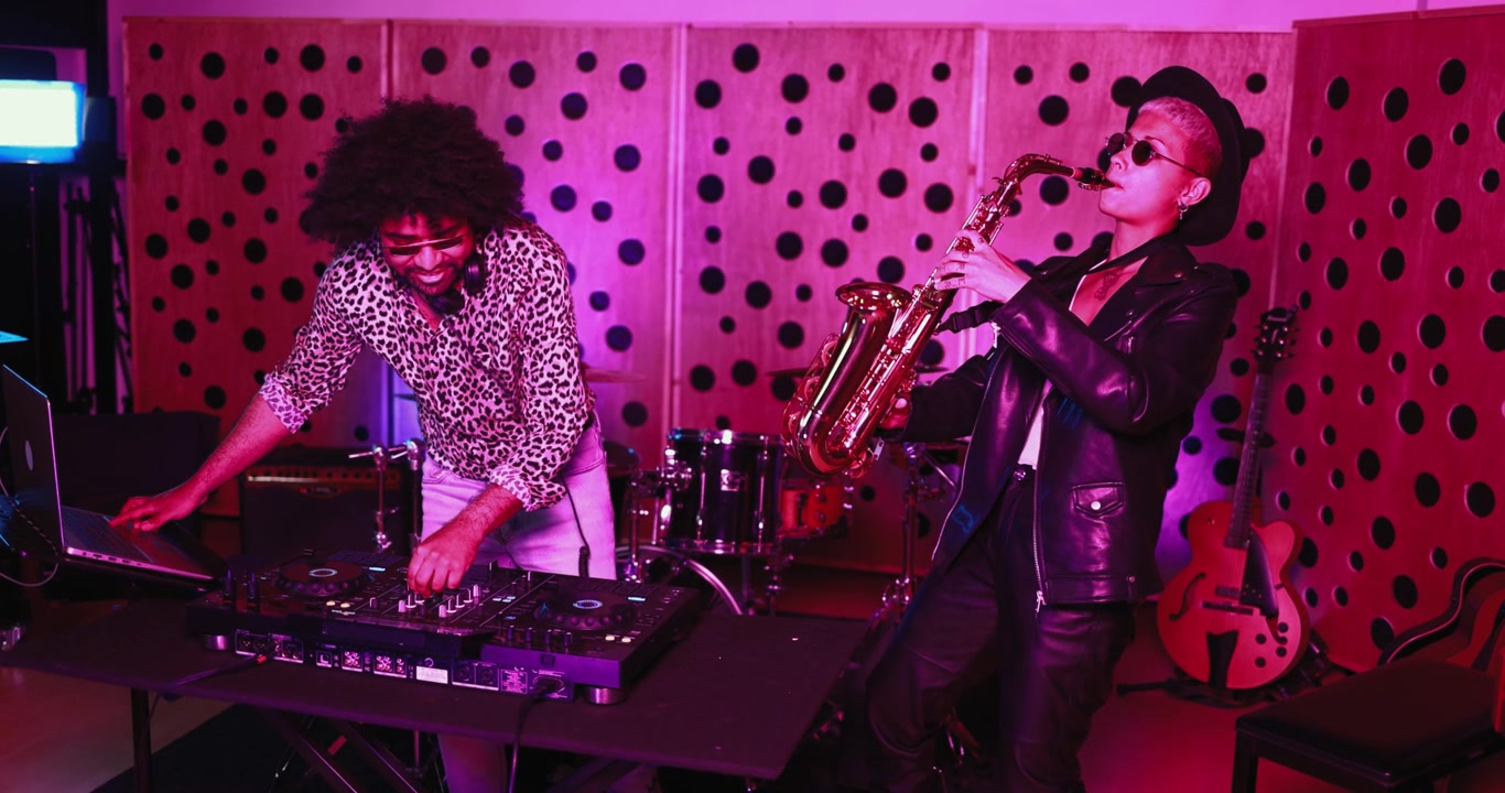 DJ e sassofonista che eseguono musica dal vivo in uno studio vivace.