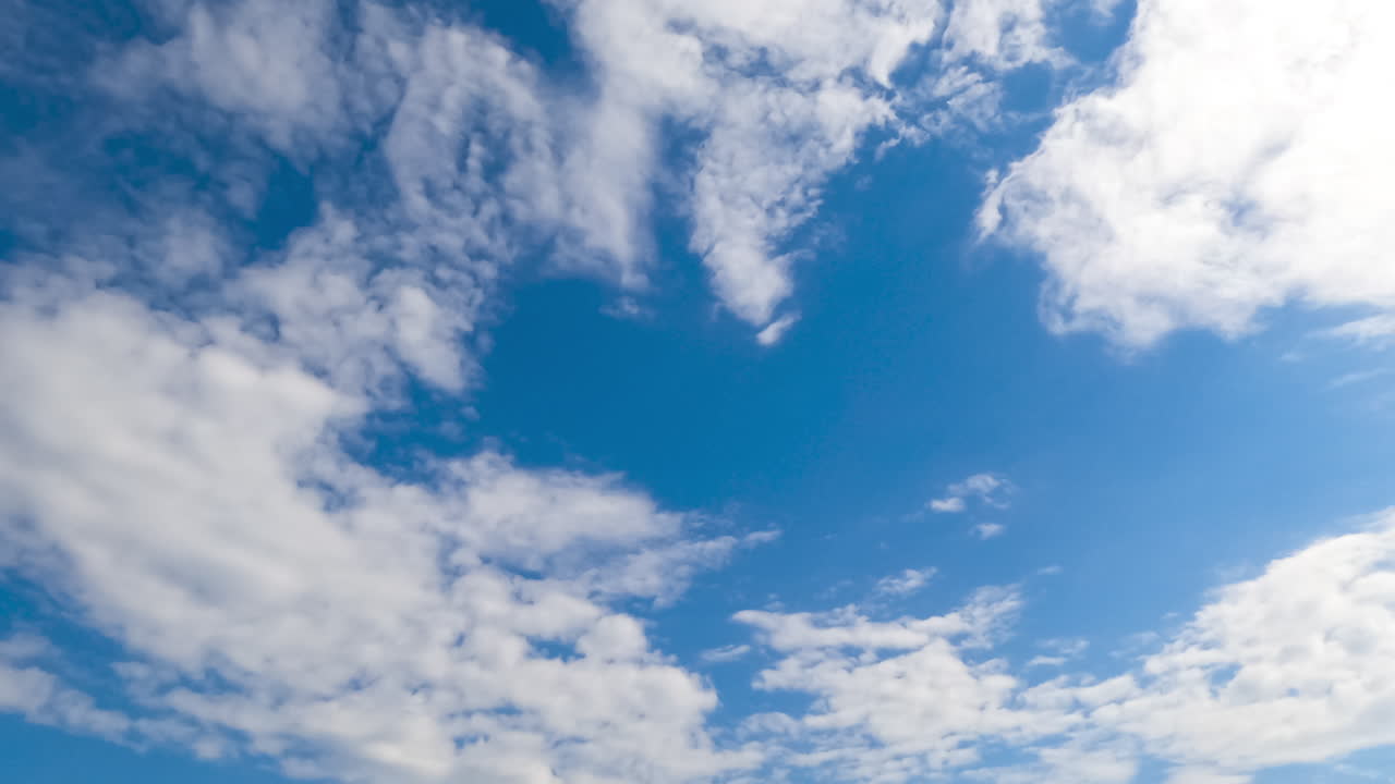 Lovely soft clouds flying with the wind quickly. Sunny azure sky in summer with spindrift white light clouds timelapse.