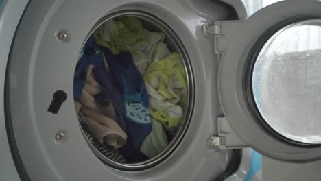 man opening and closing a washing machine door