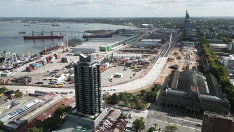 aerial-of-Montevideo-Uruguay-cityscape-with-traffic-highway-cars-driving-fast-near-the-port,-smog-pollution-concept