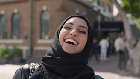 portrait of young muslim woman wearing hajib headscarf laughing happy enjoying life in city